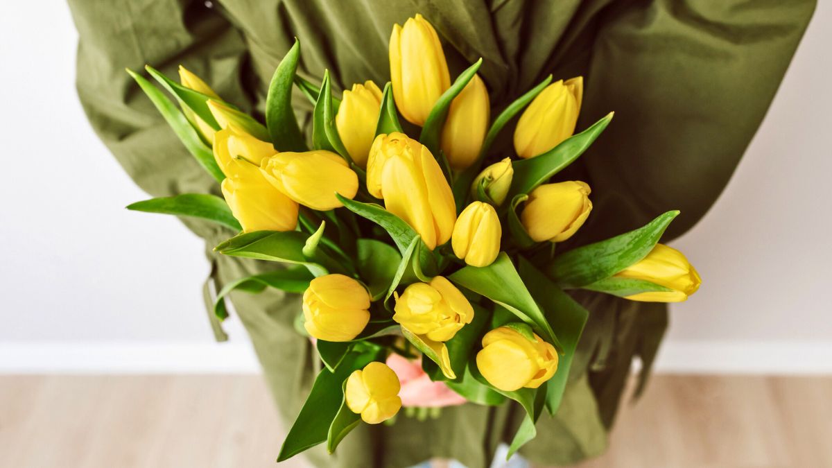 Kobieta z bukietem żółtych tulipanów
