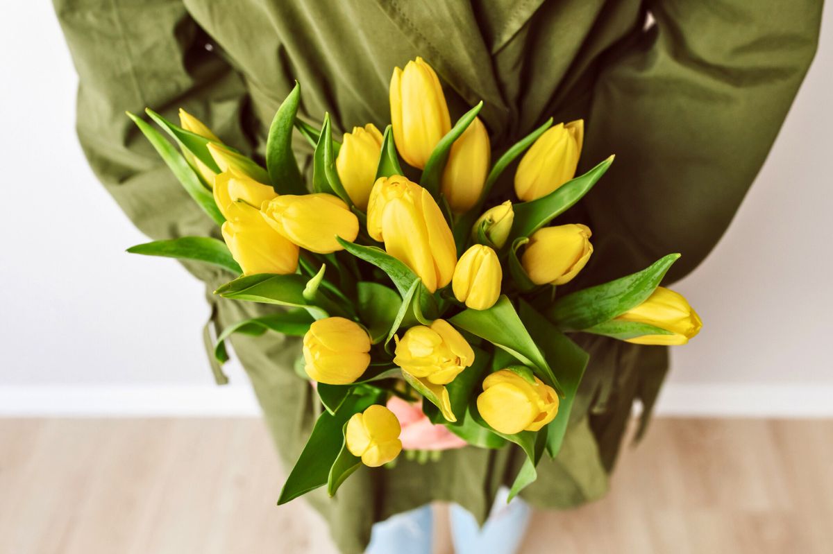 Kobieta z bukietem żółtych tulipanów