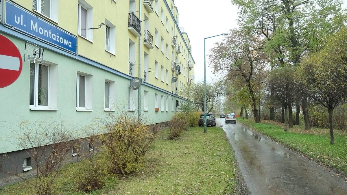 blok, chodnik, znak, trawa i krzaki
