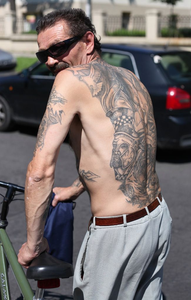 Pan Henryk eksponujący swoje tatuaże.