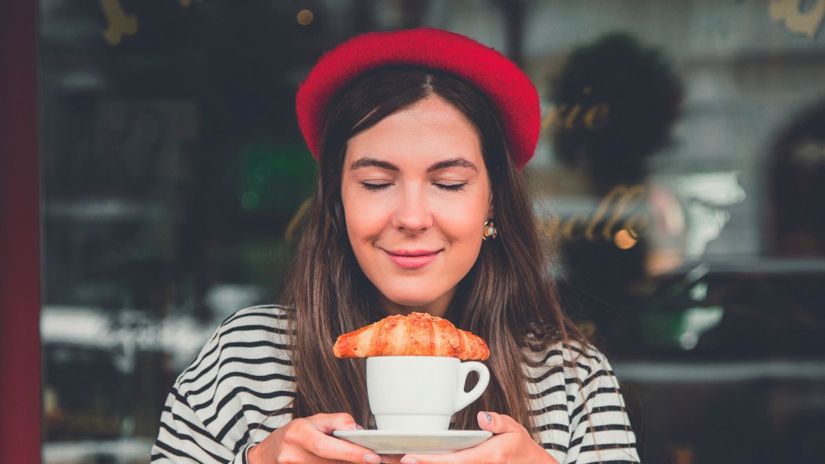 Kobieta z kawą i rogalikiem