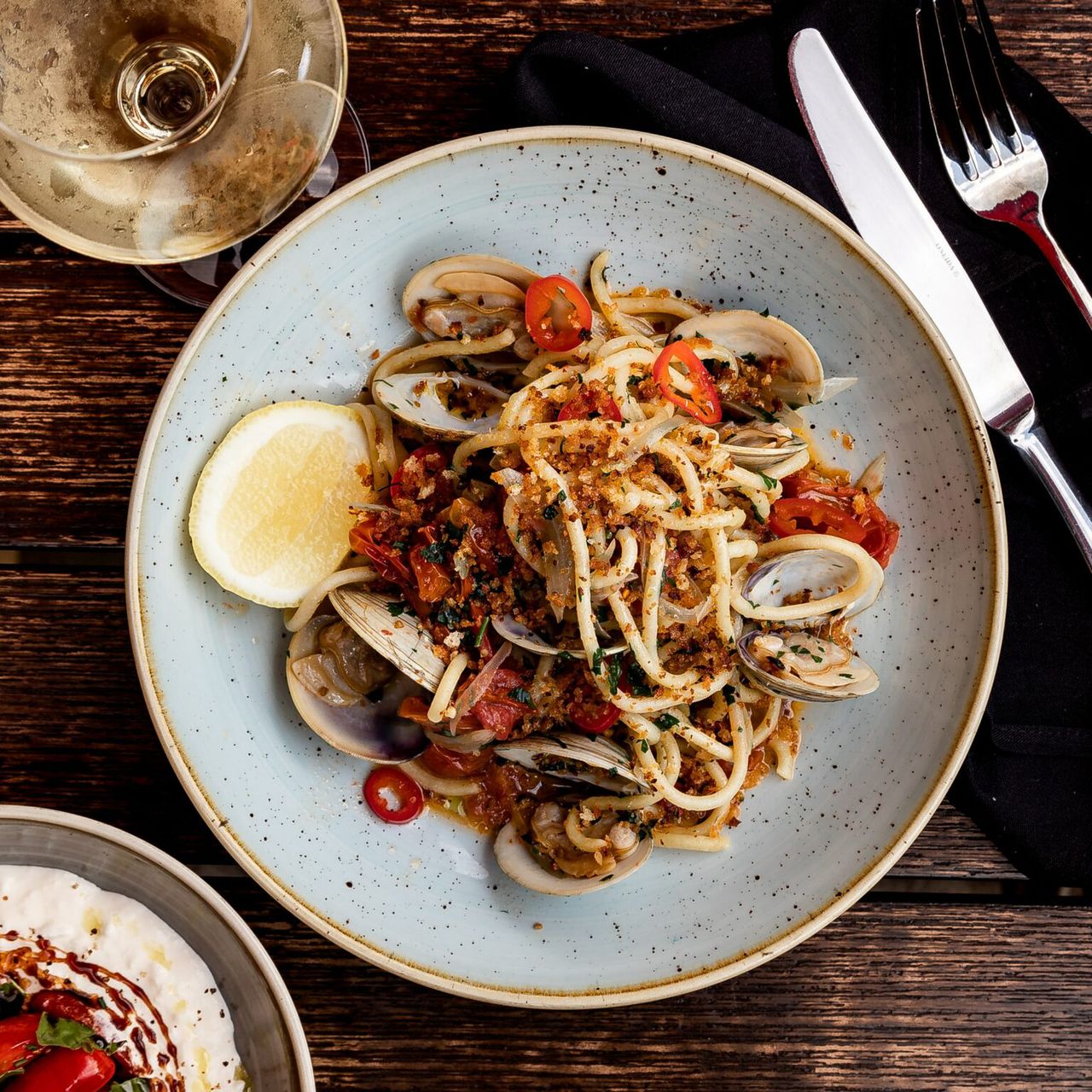 Spaghetti z małżami Wenus, pomidorkami koktajlowymi i chrupiącą posypką