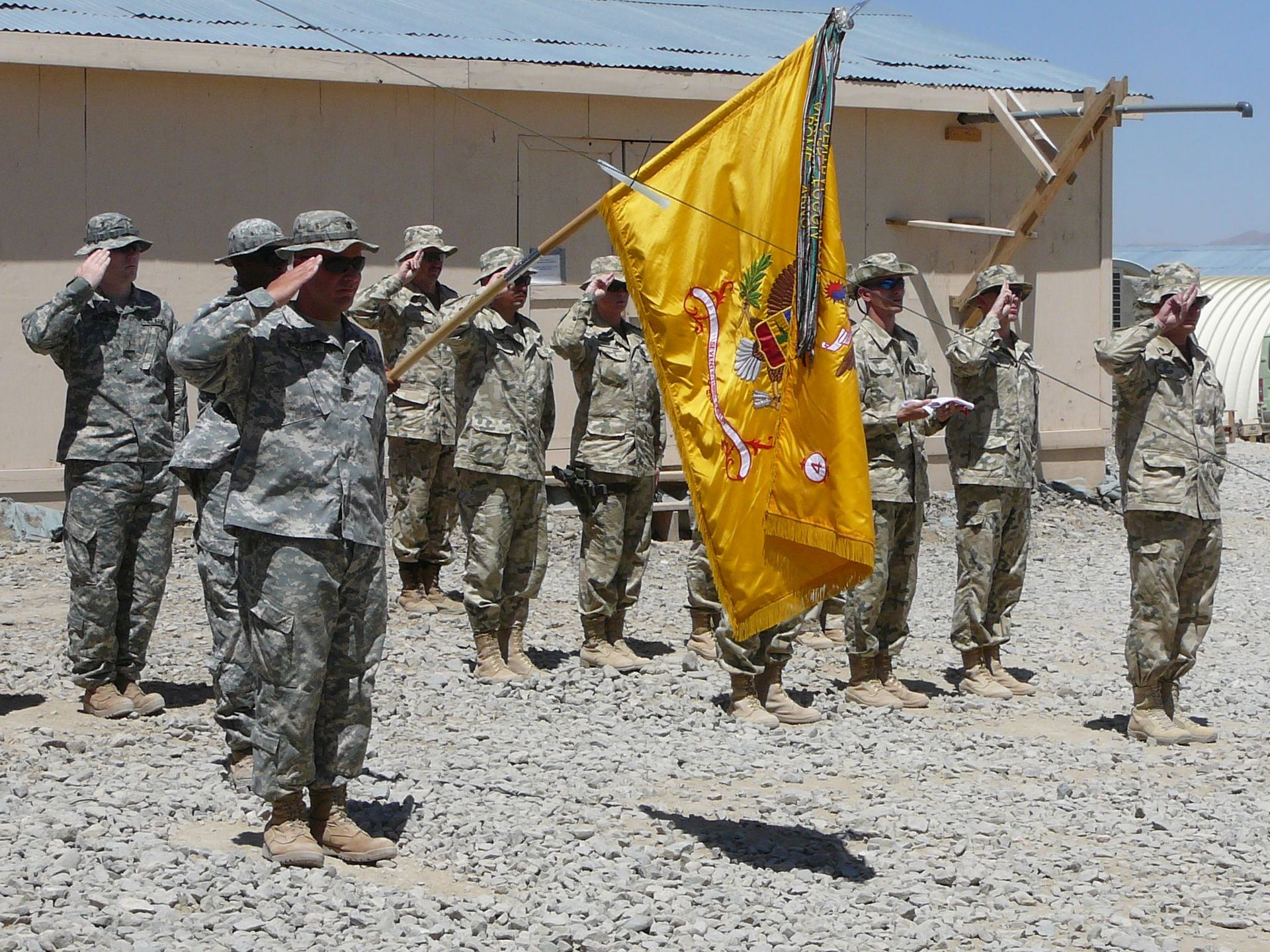 Polscy i amerykańscy żołnierze w bazie Szaran podczas uroczystości przekazania odpowiedzialności Polakom za bezpieczeństwo nad częścią prowincji Paktika, zdominowanej przez wspierających talibską rebelię Pasztunów. Lipiec 2007 roku