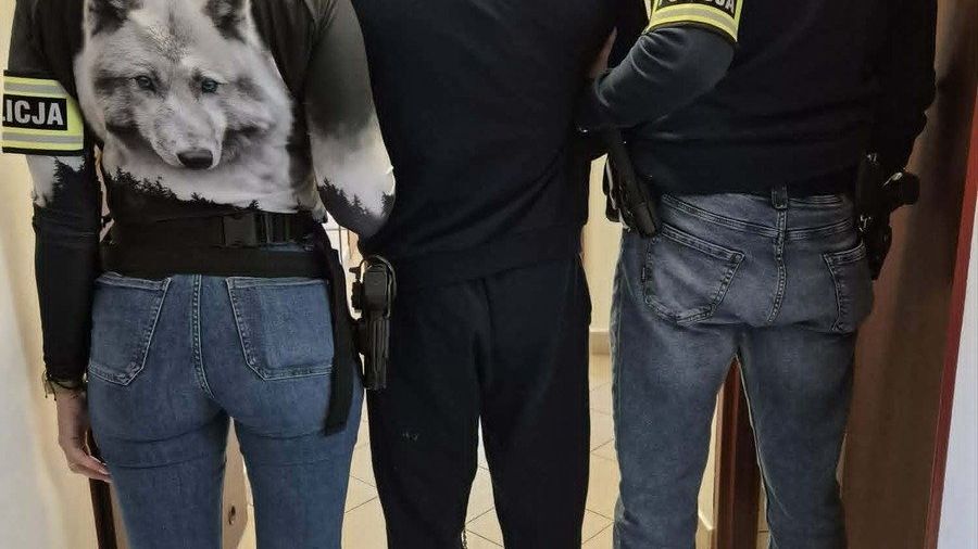 Zatrzymany mężczyzna w asyście funkcjonariuszy policji