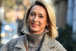 Anna Kalczyńska ubrana w szarości. Dodatkiem droga torebka