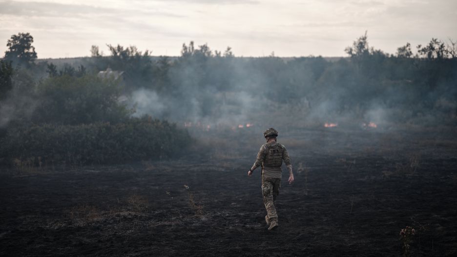DONETSK REGION, UKRAINE - 29 JULY: A soldier looks at a fire caused by artillery fire on July 29, 2024 in Donetsk region, Frontline, Ukraine. (Photo by Kostiantyn Liberov/Libkos/Getty Images)