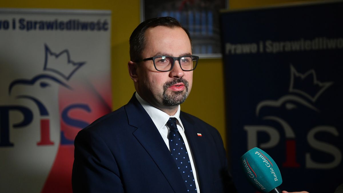 Na zdjęciu Marcin Horała na tle standów z logiem Prawa i Sprawiedliwości