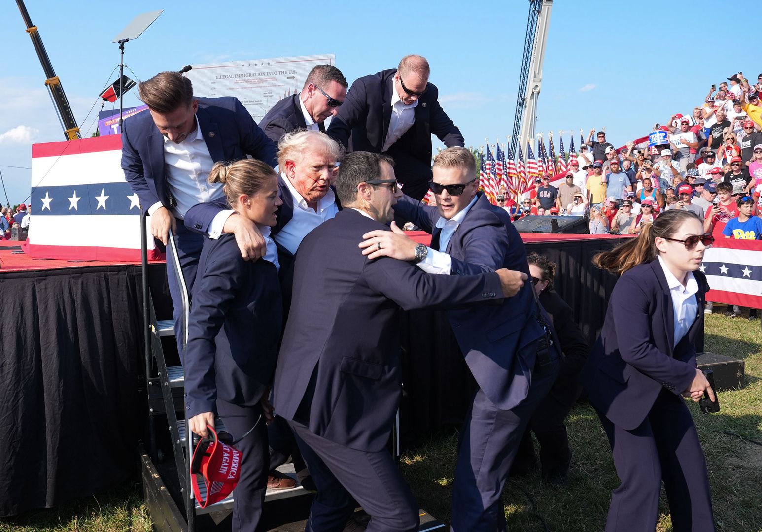 BUTLER, PENNSYLVANIA - July 13: Former president Donald Trump is assisted offstage during a campaign rally at Butler Farm Show Inc. on Saturday, July 13, 2024 in Butler, Pa. Trump ducked and was taken offstage after loud noises were heard after he began speaking. 
(Photo by Jabin Botsford/The Washington Post via Getty Images)