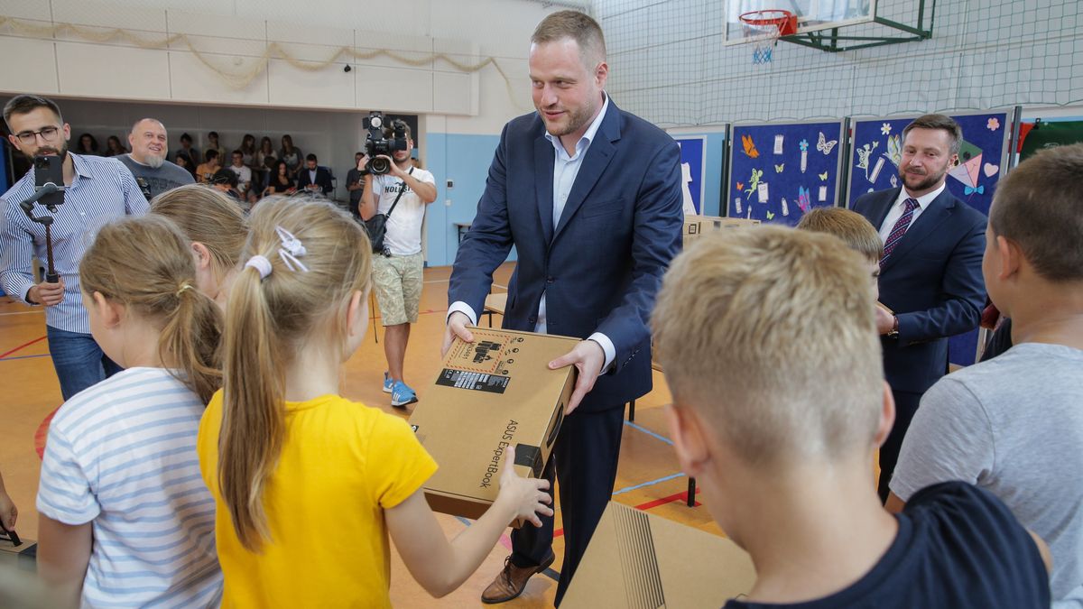 Janusz Cieszyński rozdaje laptopy dla uczniów Szkoły Podstawowej im. Marii Ziętary- Malewskiej w Dywitach k. Olsztyna