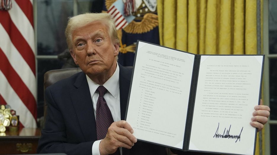 Prezydent Donald Trump pokazuje  podpisane rozporządzenie