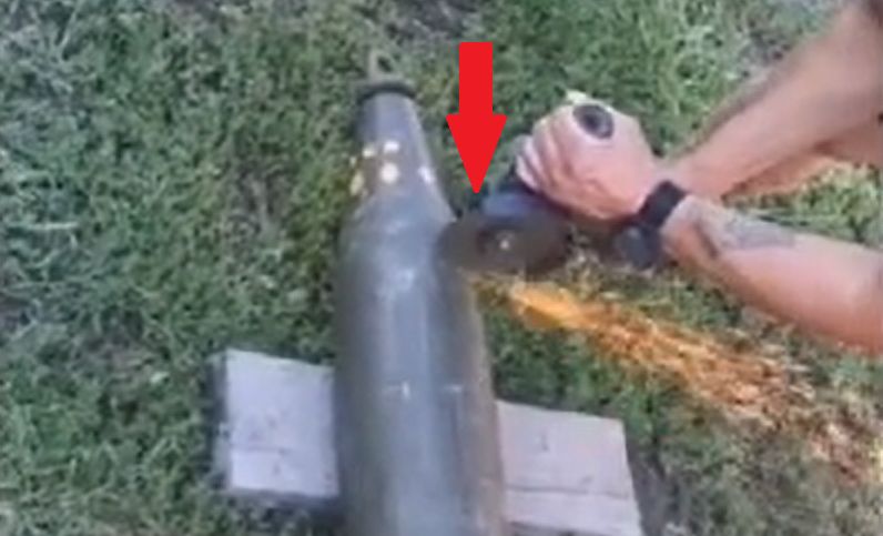 Ukrainiec używa szlifierki kątowej do demontażu pocisków z głowicą kasetową.