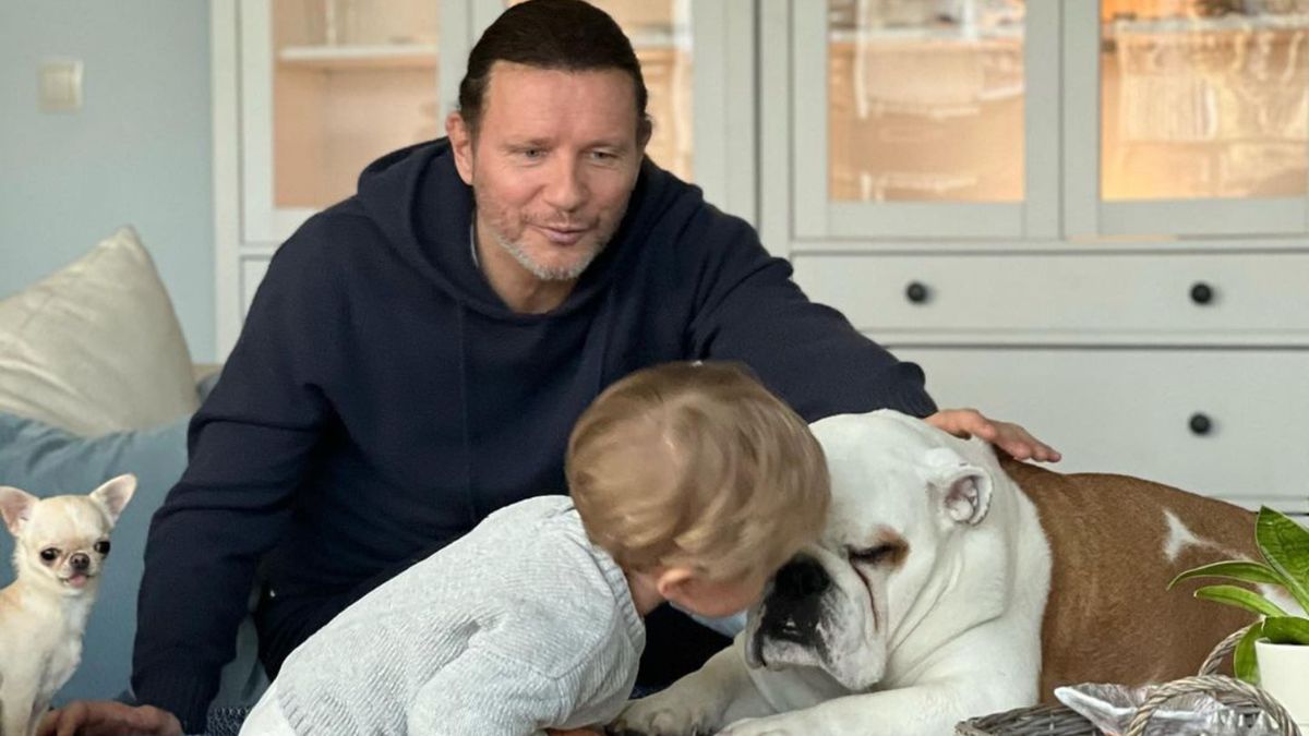 Radosław Majdan patrzy, jak jego syn bawi się z psem