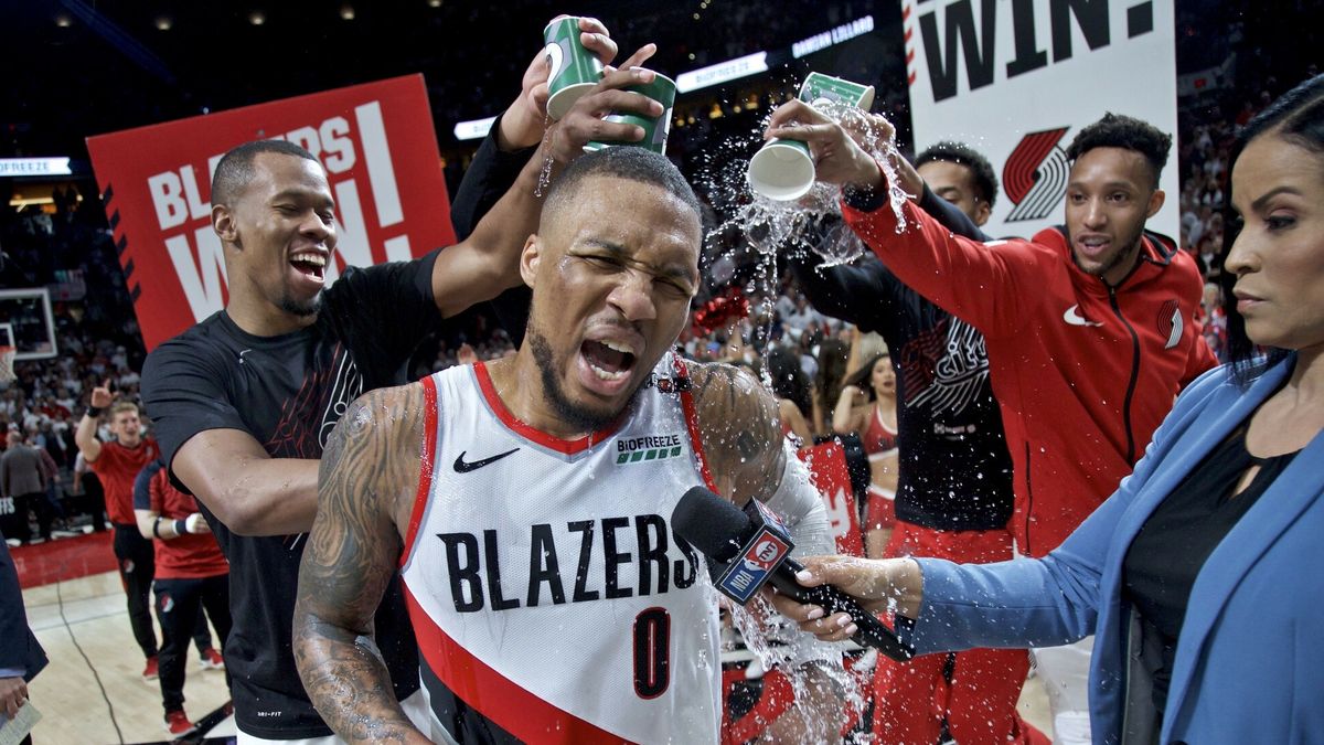 NBA - playoffy 2019Portland Trail Blazers' Damian Lillard (0) gets water poured on him by teammates Rodney Hood, left, and guard Evan Turner, right, after Game 5 of an NBA basketball first-round playoff series against the Oklahoma City Thunder, Tuesday, April 23, 2019, in Portland, Ore. The Trail Blazers won 118-115. (AP Photo/Craig Mitchelldyer), APTOPIXFR170751 AP