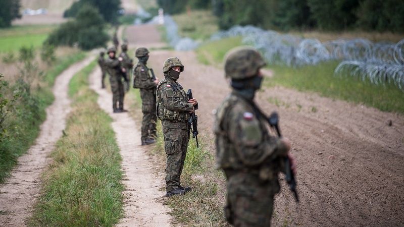 Żołnierze pilnujący płotu na granicy polsko-białoruskiej