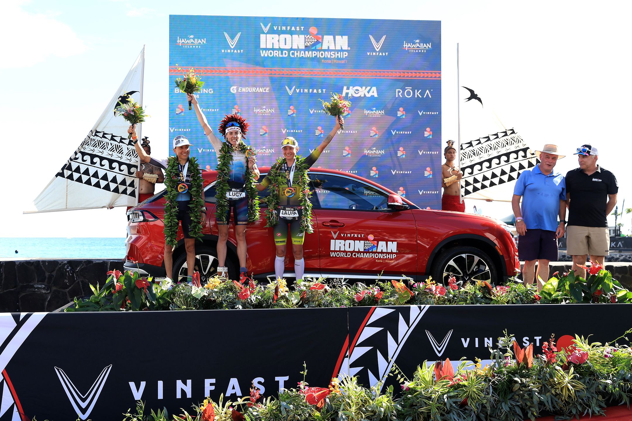 KAILUA KONA, HAWAII - OCTOBER 14: Anne Haug of Germany (2nd), Lucy Charles-Barclay of Great Britain (1st) and Laura Philipp of Germany (3rd) celebrate after finishing the VinFast IRONMAN World Championship on October 14, 2023 in Kailua Kona, Hawaii. (Photo by Sean M. Haffey/Getty Images for IRONMAN)