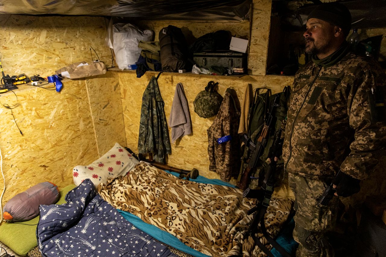 Aleksander pokazuje bezpieczne miejsce, w którym śpią żołnierze. Na ścianach widać broń i odzież.