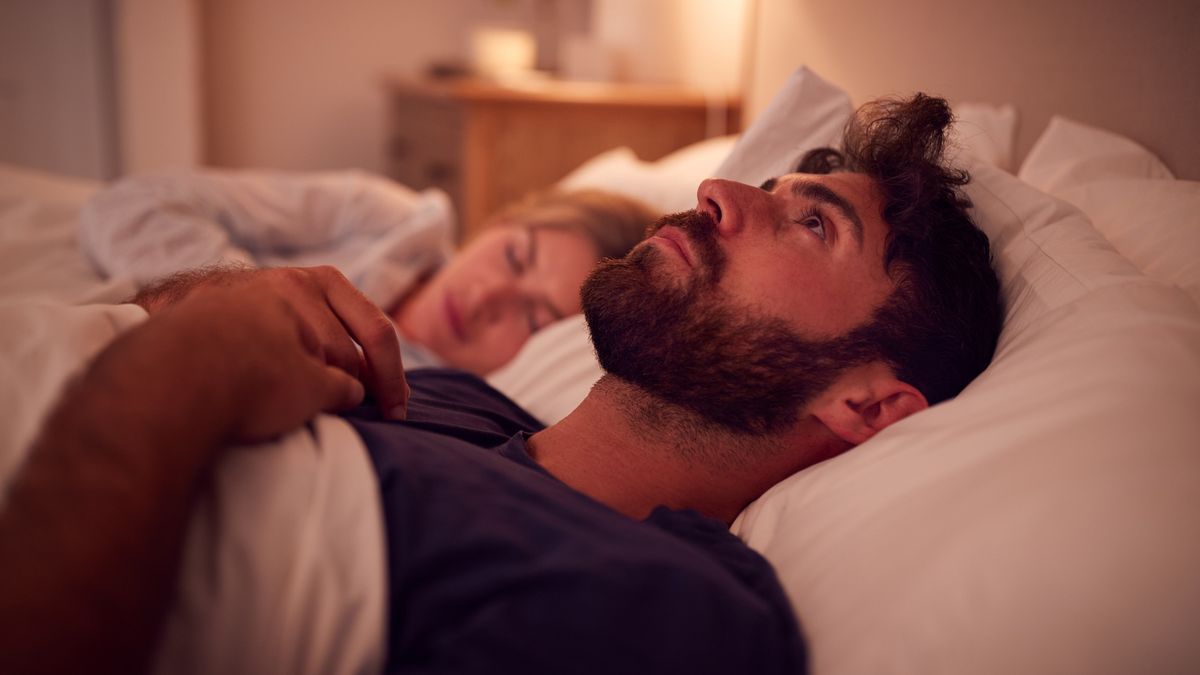 Couple With Man Lying In Bed Awake At Night Suffering With InsomniaCouple With Man Lying In Bed Awake At Night Suffering With Insomniamonkeybusinessimagescouple, man, bed, unhealthy, sleeplessness, insomniac, worry, worrying, anxious, problem, health, thinking, woman, female, male, person, caucasian, 30s, thirties, 20s, twenties