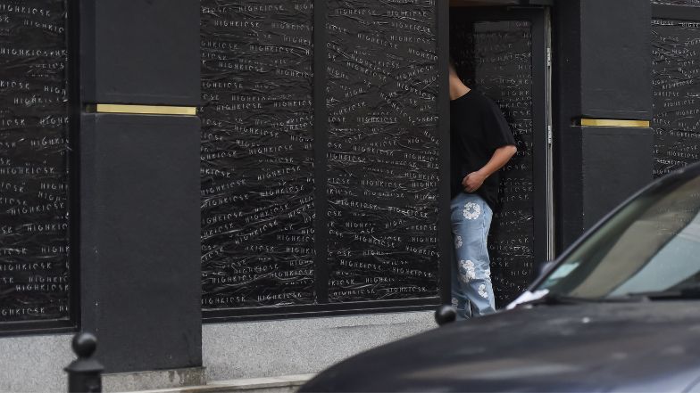 Allan Krupa pali papierosa przed butikiem