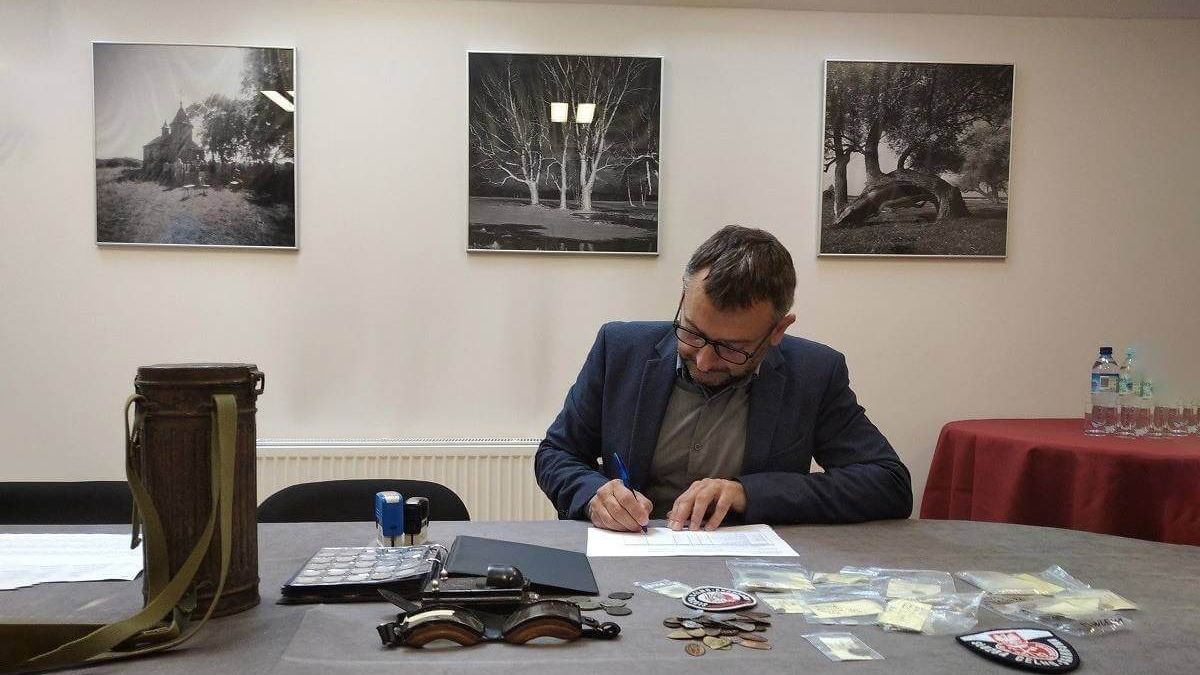 Mężczyzna przy biurku wypełnia dokumenty