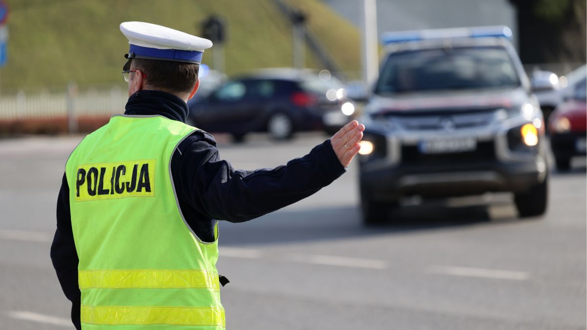 Policjant kieruje ruchem drogowym. 