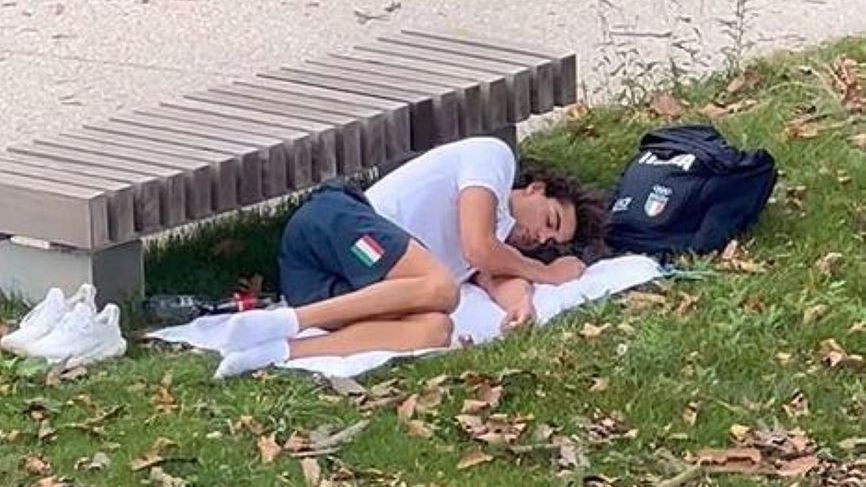 Thomas Ceccon śpiący na trawie