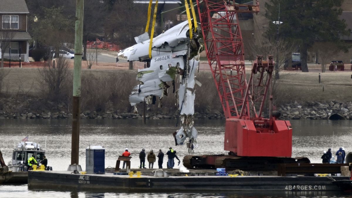 ARLINGTON, VA - FEBRUARY 3: A recovery crane pulls up a portion of the fuselage of a regional jet airliner that collided with a military helicopter on Wednesday night on the Potomac River at Reagan National Airport in Arlington, VA on February 3, 2025. (Photo by John McDonnell/ for The Washington Post via Getty Images)