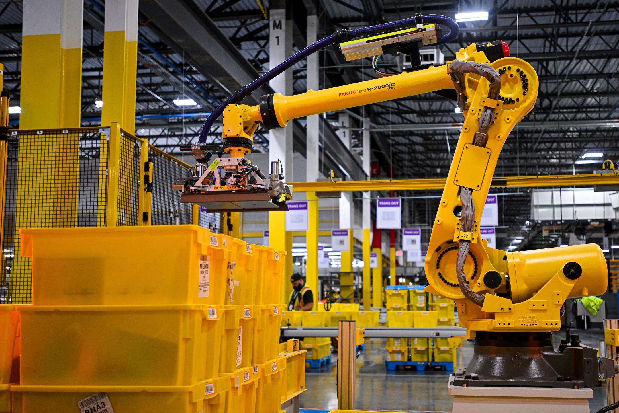A Fanuc robotic arm moves bins of products during a media tour of the Amazon.com Inc. DAB2 fulfillment center in Daytona Beach, Florida, US, on Tuesday, Sept. 23, 2025. The DAB2 fulfillment center is Amazon's seventh robotics fulfillment center in Florida. Photographer: Miguel J. Rodriguez Carrillo/Bloomberg via Getty Images