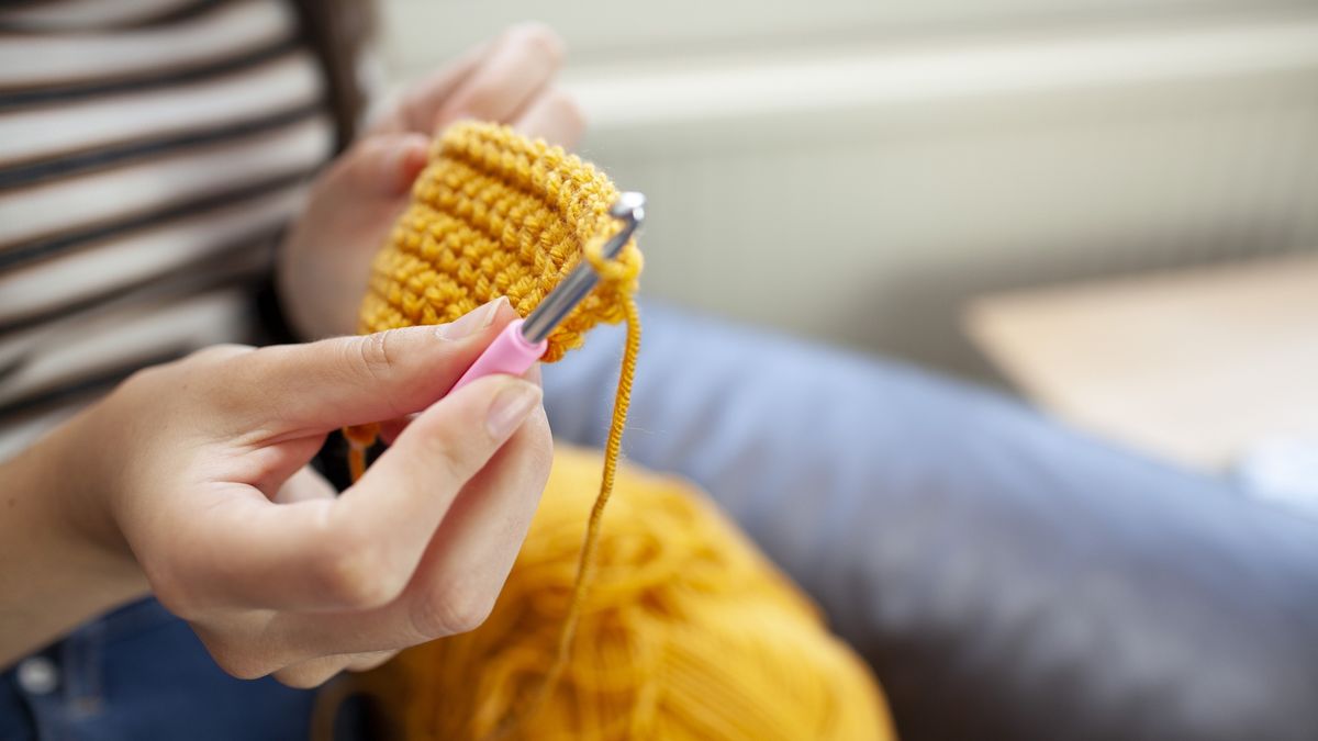 Young woman crocheting with yellow wool
Close-up of hands doing crochet
Peter Carruthers
