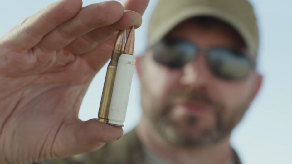 Nowy nabój 6,8 TVCM w plastikowej łusce na tle klasycznego 7,62x51 mm NATO w mosiężnej łusce.