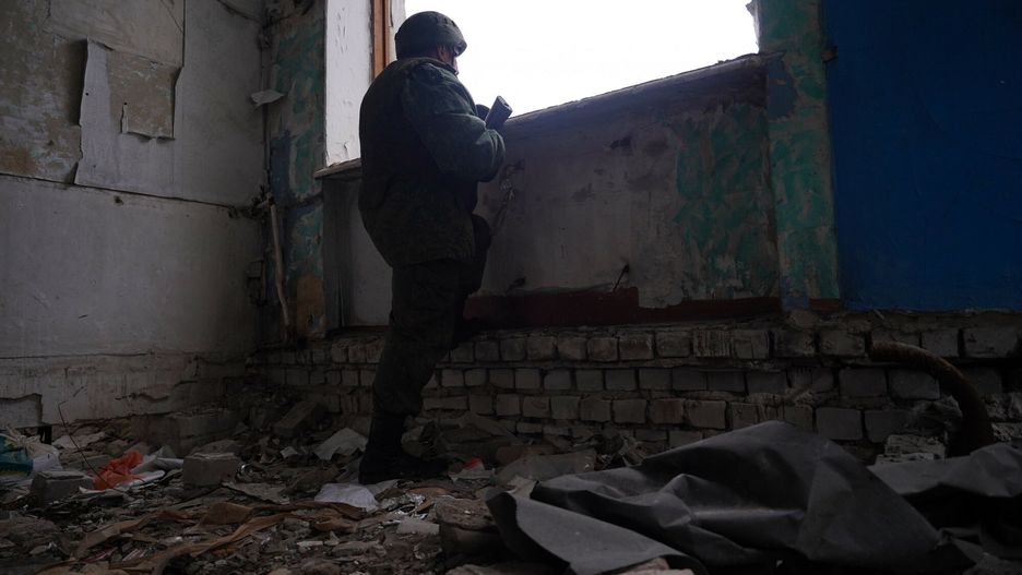 ?o?nierze samozwa?czej Donieckiej Republiki Ludowej na linii frontu8119196 17.02.2022 A serviceman of the Luhansk People's Republic (LPR) inspects a ruined school on the contact line with Ukrainian armed forces in the village of Molodezhniy in Luhansk region, self-proclaimed Luhansk People's Republic, Eastern Ukraine. Maxim Zakharov / SputnikMaxim Zakharov