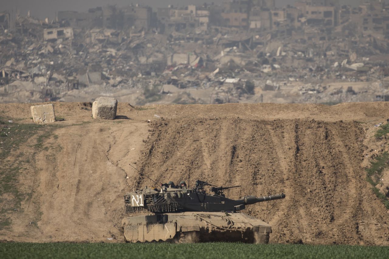 SOUTHERN ISRAEL, ISRAEL - JANUARY 19: An Israeli tank moves along the border with the Gaza Strip, as seen from a postion on the Israeli side of the border on January 19, 2024 in Southern Israel, Israel. Israel increased air raids in the south of the Gaza Strip, where medicines are expected for hostages held by Hamas and humanitarian aid for the Palestinian population. Despite Israel's recent troop drawdown in Gaza and the discussion of postwar plans by an Israeli cabinet minister, the country has continued its intensive bombardment of the Gaza Strip, particularly in the territory's south, as it seeks to destroy Hamas, the Palestinian militant group behind the Oct. 7 attacks. At least 1,200 civilians and soldiers have been killed in Israel since October 7 along with some 190 IDF soldiers killed fighting in Gaza ground operations, while more than 24,000 people have been killed in Gaza in the last three months, according to the territory's health ministry, and most of the population has been displaced. (Photo by Amir Levy/Getty Images)