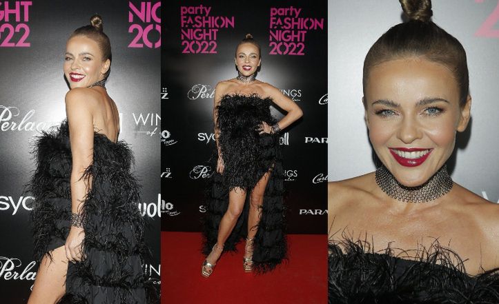 Figlarna Edyta Herbuś gra nogą w pierzastej kreacji na modowej imprezie