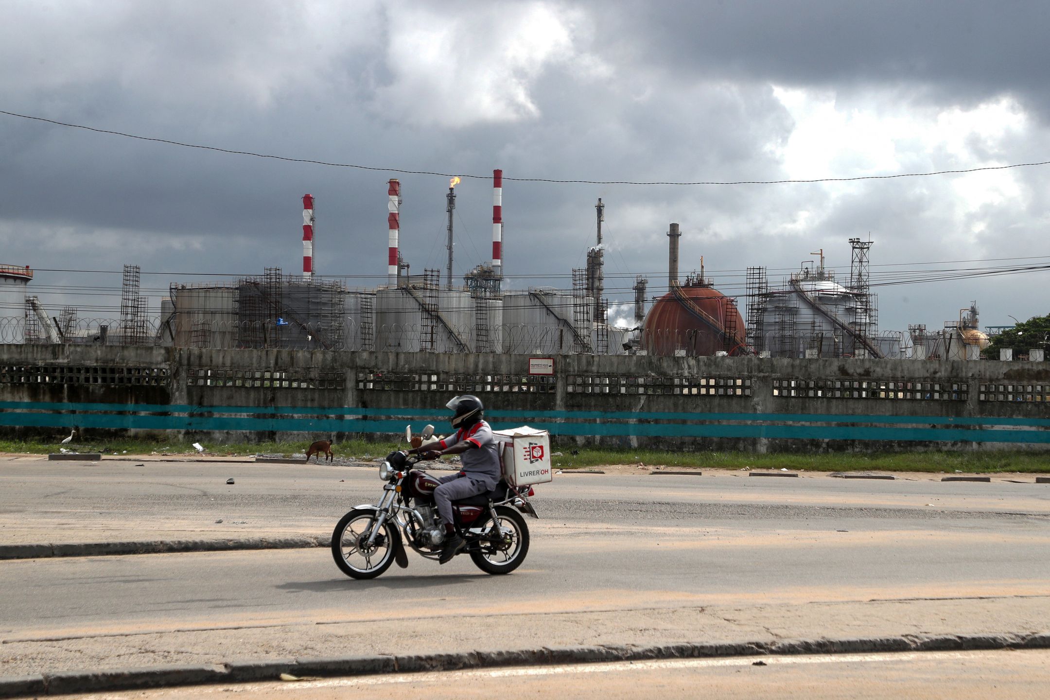 A motorcyclist drives past the Ivorian Refining Company (SIR) facilities in Abidjan, Ivory Coast, 17 June 2025. Recent military escalations between Israel and Iran are raising fears of a potential closure of the Strait of Hormuz, a crucial waterway for global oil and gas trade, which could significantly impact global energy markets, causing a sharp increase in oil prices. EPA/LEGNAN KOULA Dostawca: PAP/EPA.