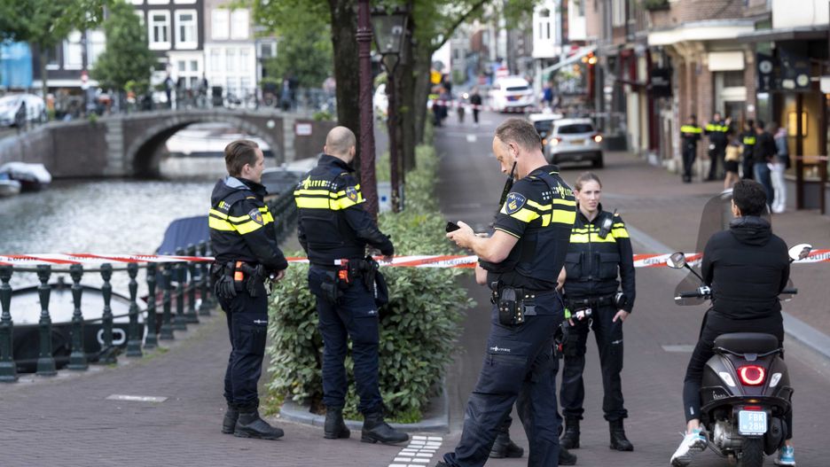epa09327502 A police officers stand guard after a man was shot on Lange Leidsedwarsstraat in Amsterdam, the Netherlands, 06 July 2021. According to statements from the police, journalist Peter R de Vries was shot and wounded in the city center. Emergency services transported de Vries to a hospital, where he remains in serious condition. Three suspects are in custody.  EPA/Evert Elzinga Dostawca: PAP/EPA.