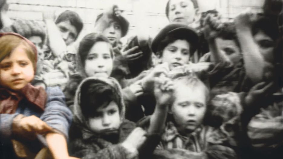 Tova (wyróżniona kolorem po lewej) i inne ocalałe dzieci pokazują swoje tatuaże radzieckim fotografom po wyzwoleniu obozu Birkenau, 1945 r.