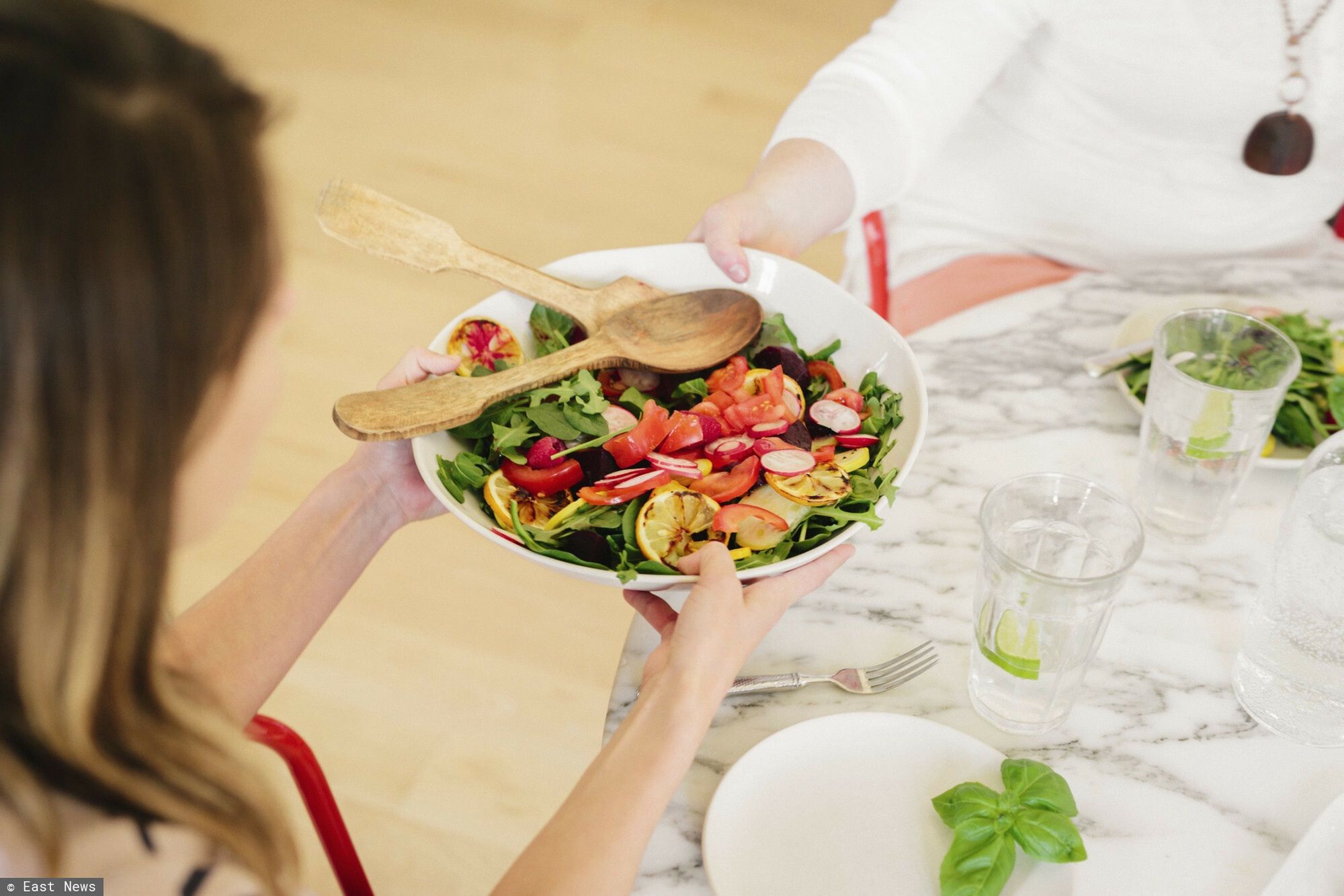 Mint Images RF batch 63 Aug 2016
View from above of a table laid with cutlery and plates of prepared food. A woman holdng a salad plate.
Mint Images