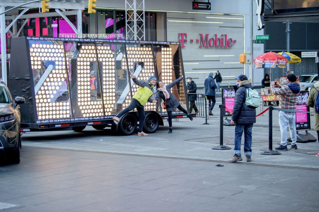 Ludzie pozują przy napisie "2021", które w noc sylwestrową stanie na szczycie jednego z budynków na Times Square