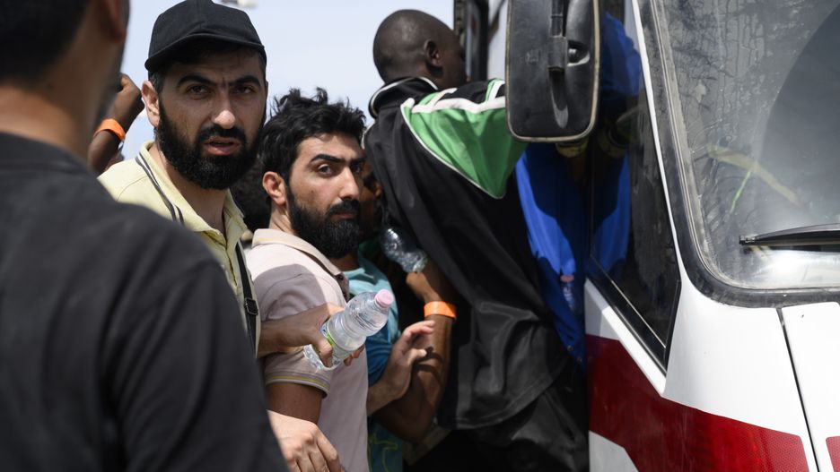 LAMPEDUSA ISLAND, ITALY - SEPTEMBER 16: Migrants seen while trying to enter in a bus in Lampedusa, Italy on September 16, 2023. The small Sicilian island of Lampedusa is overwhelmed with nearly 7000 migrants arrived in the last 48 hours. The majority of migrants, mainly of African origins, departed from Tunisia. People working in the humanitarian assistance are facing increasing difficulties in transferring and hosting people in the hotspot, which could normally host 400 migrants. Local and regional authorities asked help from the Italian Government to deal with the emergency situation. (Photo by Valeria Ferraro/Anadolu Agency via Getty Images)