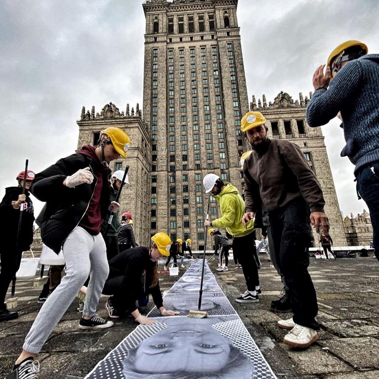 Warszawa. Przyklejanie zdjęć przy PKiN 