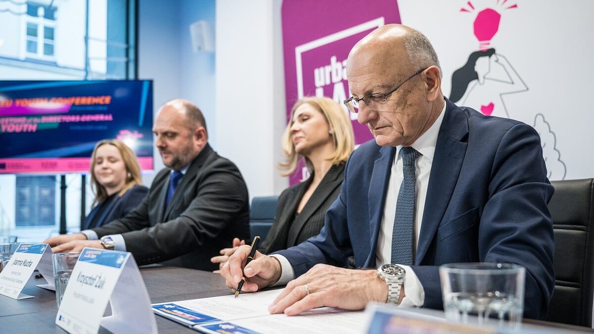 Krzysztof Żuk podpisujący dokument