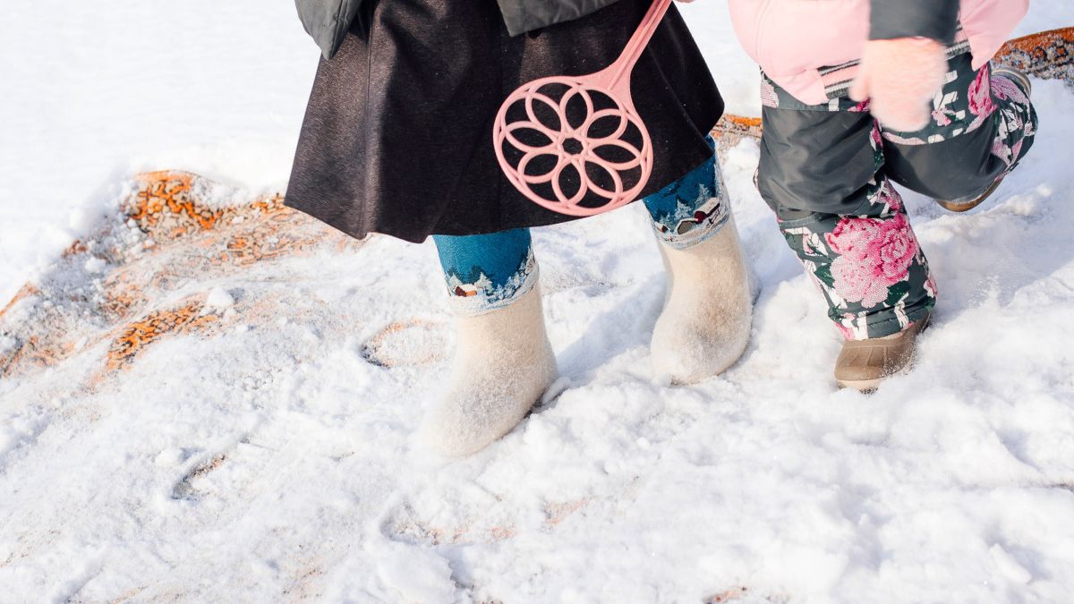 Kobieta czyści dywan zimą