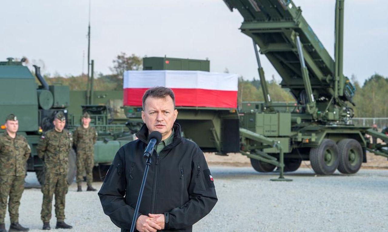 Mariusz Błaszczak na tle wyrzutni Patriot.