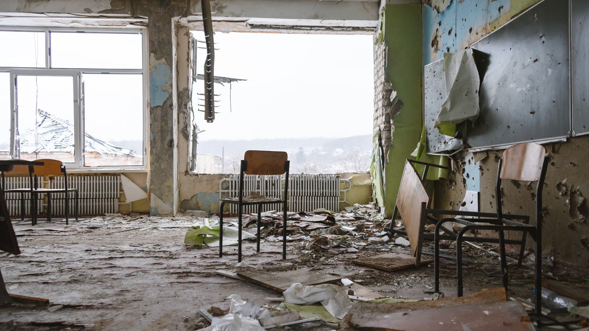 STARYI SALTIV, UKRAINE - FEBRUARY 1: A classroom in a damaged school with debris scattered around the room on February 1, 2023 in Staryi Saltiv, Ukraine. A couple of chairs are standing and a fixture is seen hanging from the damaged ceiling, and most notably, there is a large hole in the room where a window used to be. The destruction serves as a stark reminder of the impact of the ongoing Ukraine-Russia war on the local communities. (Photo by Lina Chu/Global Images Ukraine via Getty Images)