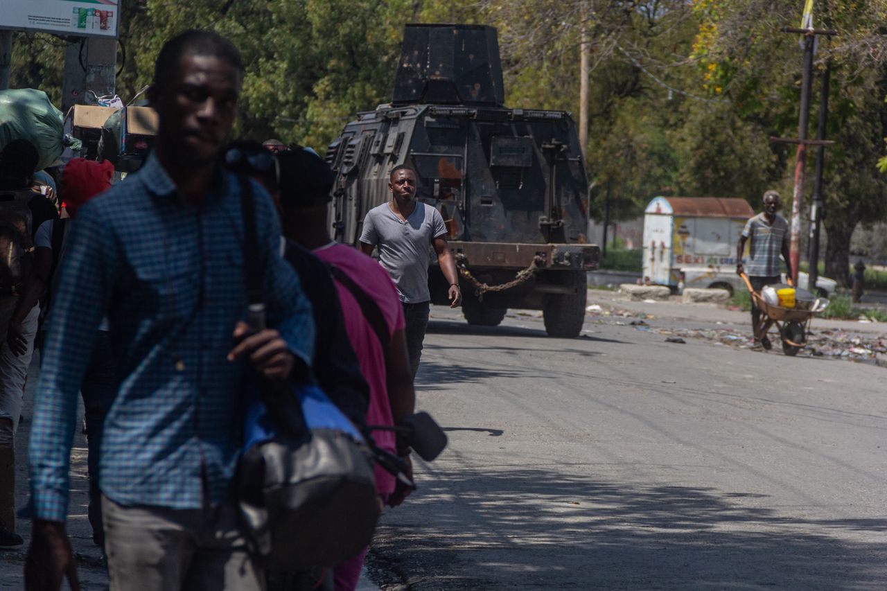 PORT-AU-PRINCE, HAITI - MARCH 09: People leave their places after seeing the armored police car, as Haitians forced to flee their homes amid spiraling gang violence in port-au-prince, Haiti on March 9, 2024. An initial three-day curfew was announced over the weekend, but gangs have continued attacking police stations and other official institutions, which has the police besieged and outnumbered to combat the armed gangs. According to official figures, a dozen police buildings have been attacked. (Photo by Guerinault Louis/Anadolu via Getty Images)