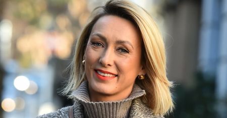 Anna Kalczyńska ubrana w szarości. Dodatkiem droga torebka