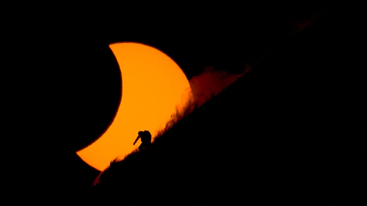 Epickie zdjęcia narciarzy na tle zaćmienia słońca