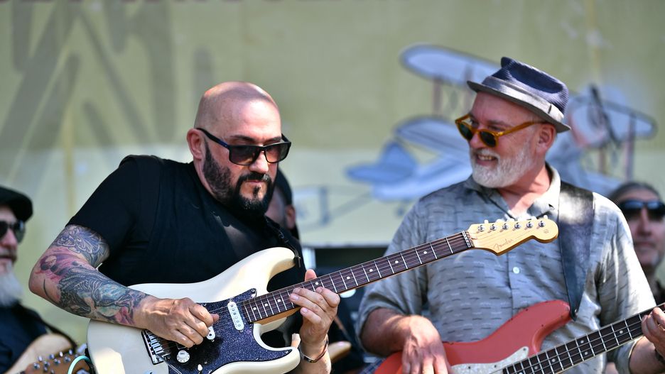 Wrocław, 19.06.2021. Grzegorz Skawiński (L) podczas wydarzenia "Największa Gitarowa Orkiestra Świata" we Wrocławiu, 19 bm. Podczas wydarzenia podjęto próbę pobicia rekordu świata liczby osób, jednocześnie grających na gitarach utwór Jimiego Hendrixa "Hey Joe". (amb) PAP/Maciej Kulczyński