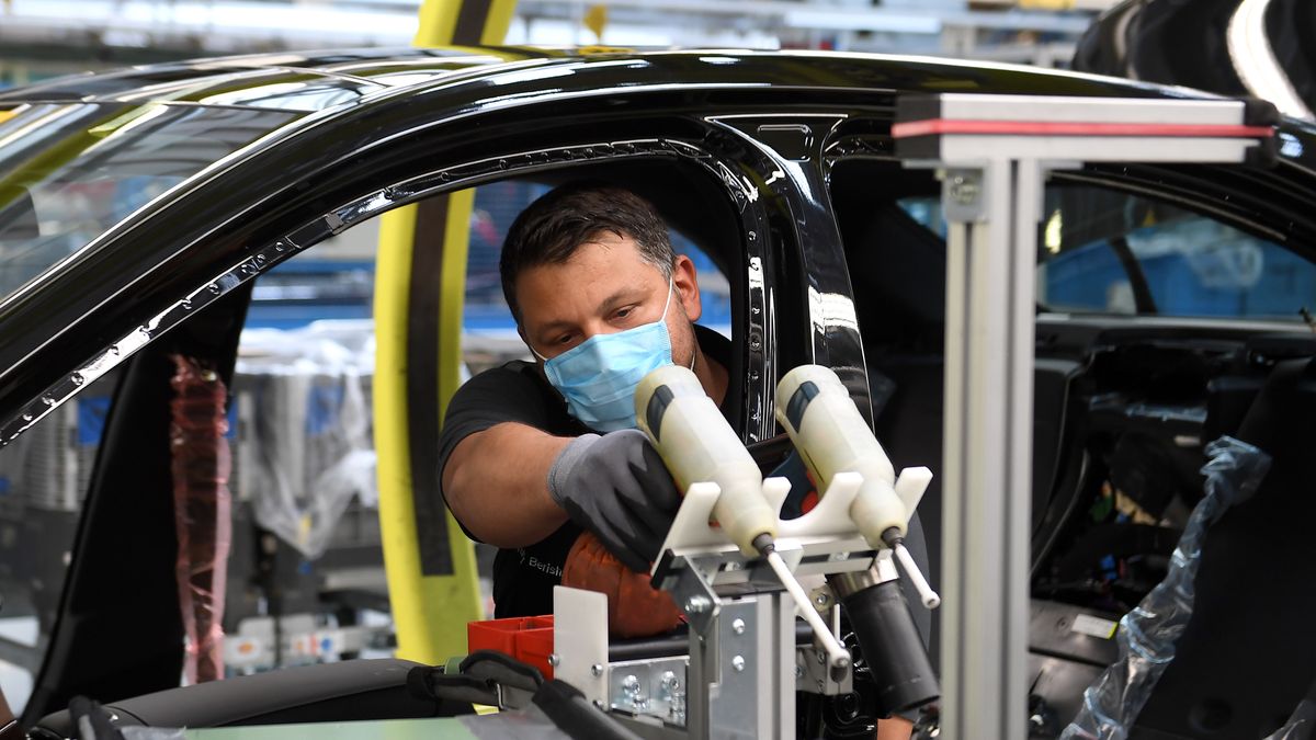 SINDELFINGEN, GERMANY - APRIL 30: Workers wear protective face masks as they assemble cars at the Mercedes-Benz factory following the resumption of automobile production this week during the novel coronavirus crisis on April 29, 2020 in Sindelfingen, Germany. Auto production at car manufacturers' factories across Germany had been shut down since March due both to lockdown measures meant to stem the spread of the virus as well as disruptions in supply chains. Many factories have reopened this week as Germany takes careful steps to ease restrictions in a bid to revive economic activity. (Photo by Matthias Hangst/Getty Images)
