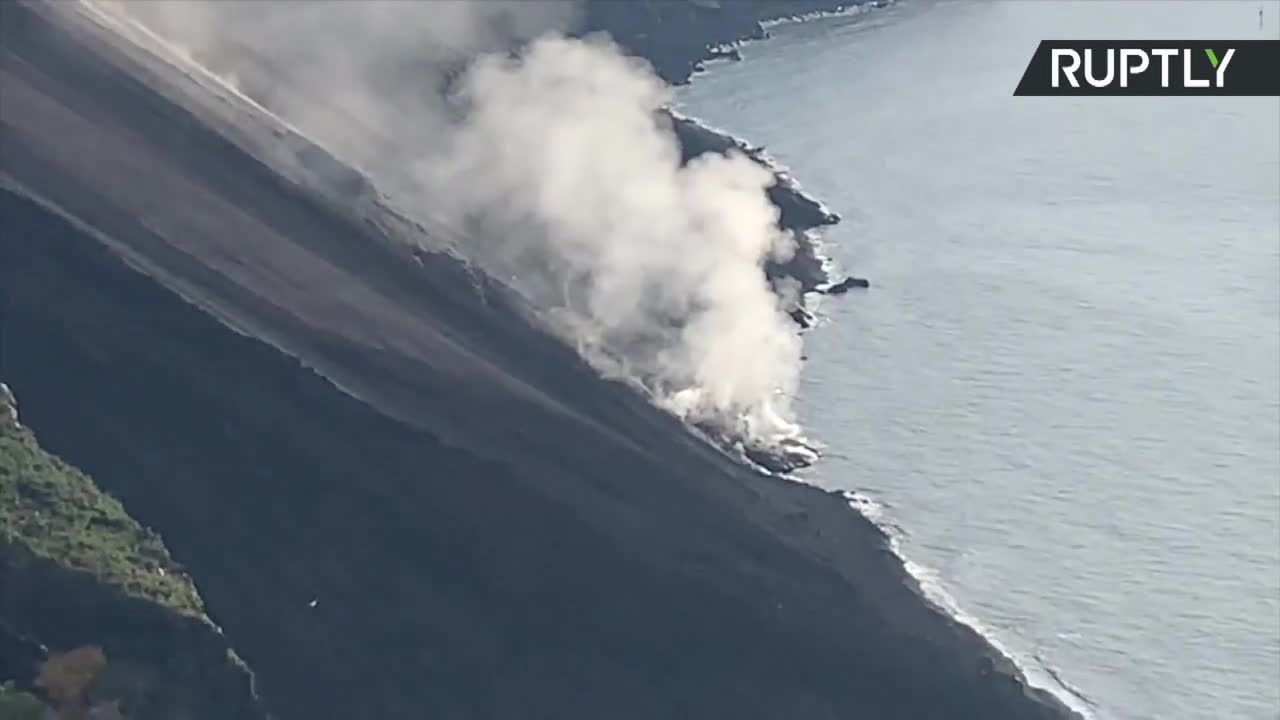 Erupcja wulkanu Stromboli we Włoszech. Z krateru unosił się dym, a lawa płynie do morza