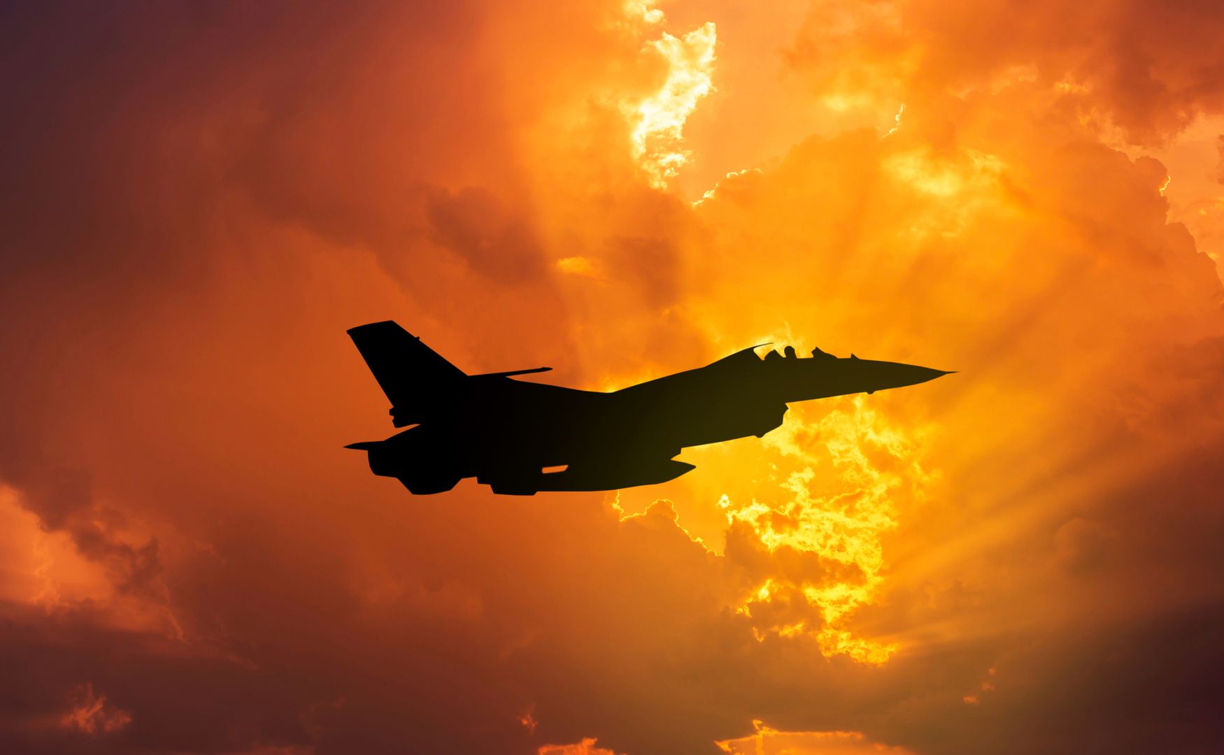 silhouette F-16 falcon fighter jet military aircraft flying on sunset  background